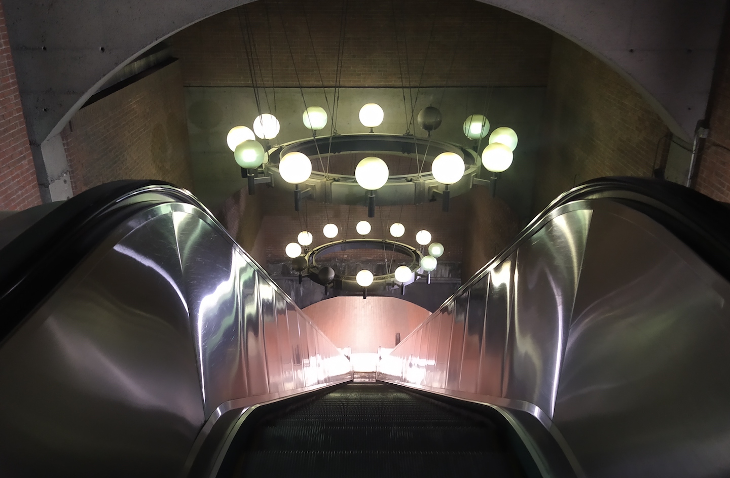 Luminaires au-dessus d’un escalier mécanique dans une station de métro