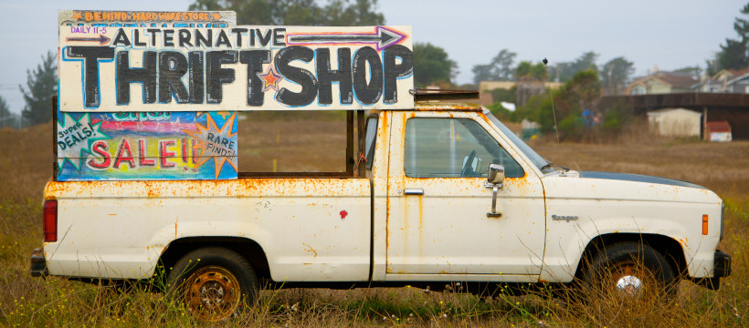 Pick-up rouillé portant une affiche artisanale indiquant « alternative thrift shop ».
