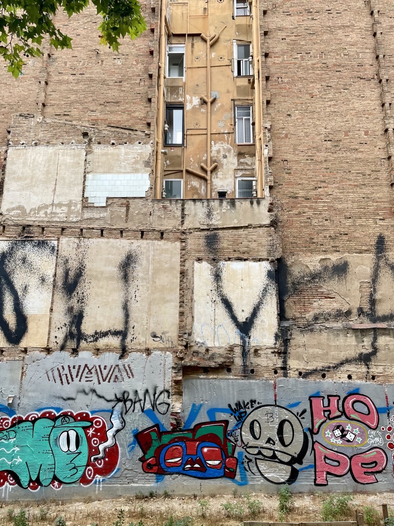 Façade d'immeuble à Barcelone, avec des graffitis au premier plan
