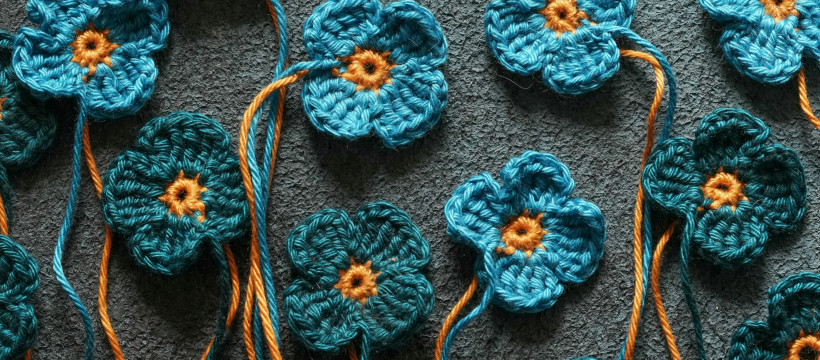 Fleurs en crochet sur un mur en crépi.